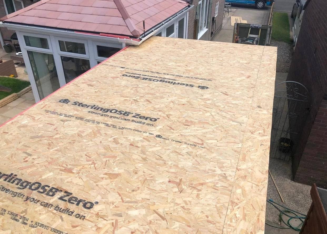 A new OSB deck laid across a flat roof, ready for the membrane to go over it