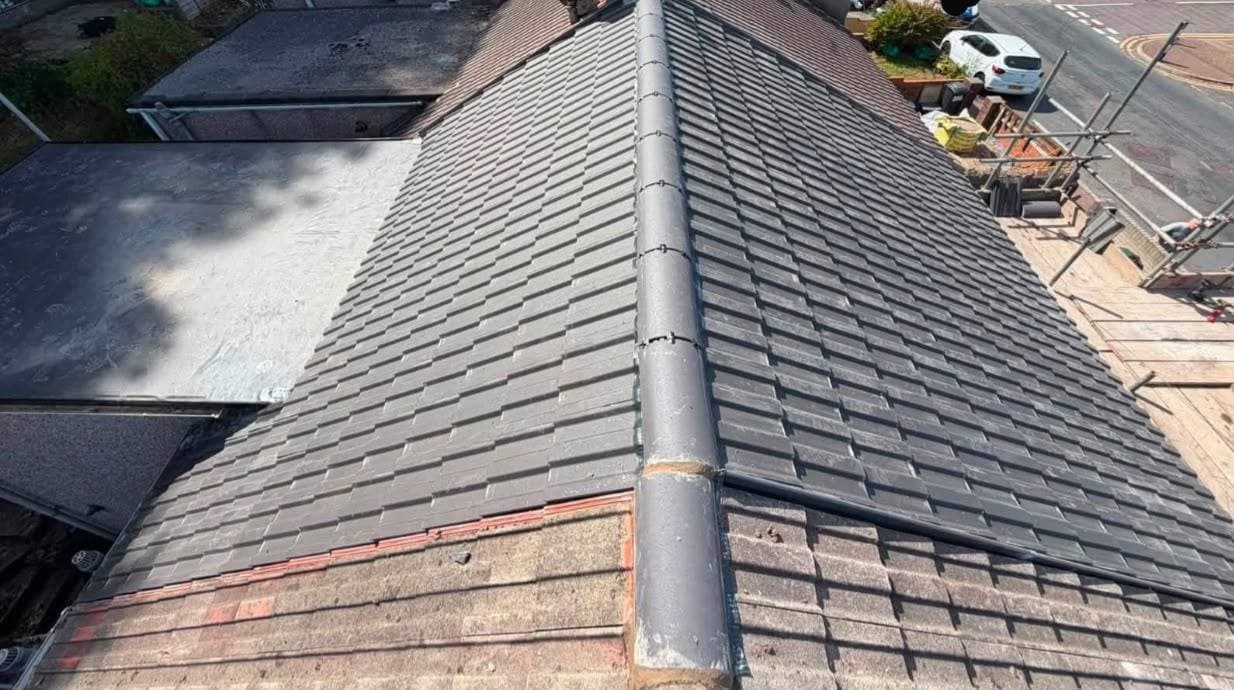 A finished reroof seen along the ridge, new ridge tiles bedded the full length of it