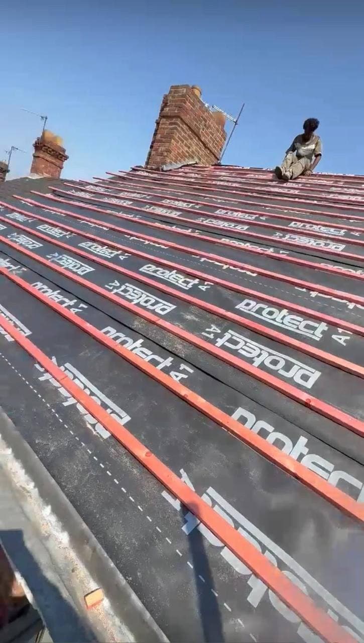 New breather membrane and treated battens fixed the full length of a roof, up to the chimney stacks